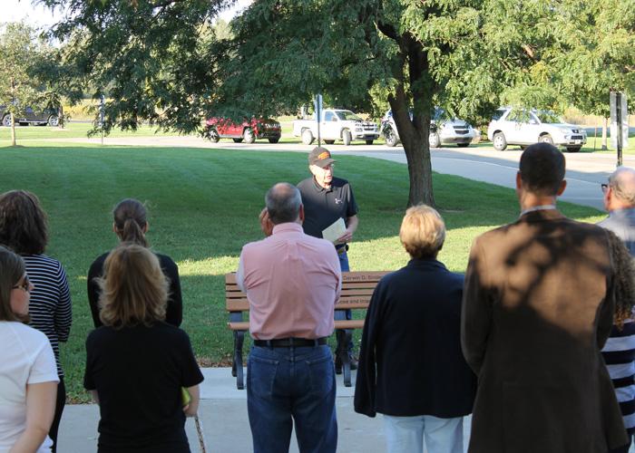 Speaking to those who came to the ceremony on September 14, Merelyn Snider offers the memorial bench to the school board and shares his fond memories of his brother Darwin in front of Stockbridge High School.