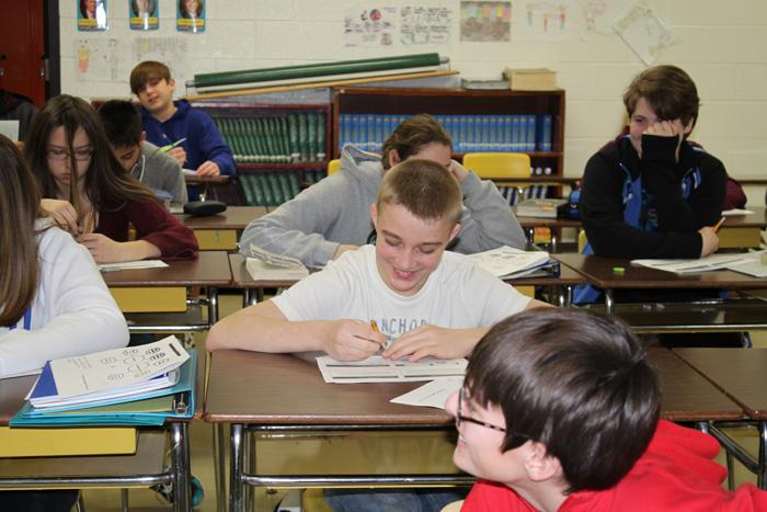 Having never been photographed by the
high school news team, 8th grader Mason
Beauregard shies away from the camera
while studying the French and Indian war
in U.S. history class.