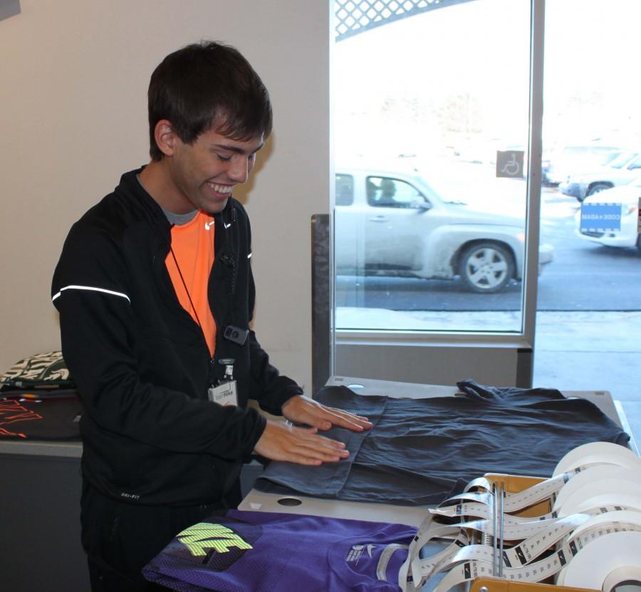 On a Sunday afternoon, working his part-time job at Nike in the Tanger outlet mall in Howell, senior Evan Meade folds  T-shirts to place on display in order to draw in customers. I experienced the typical seasonal winter drop in hours after the holiday rush, said Meade.