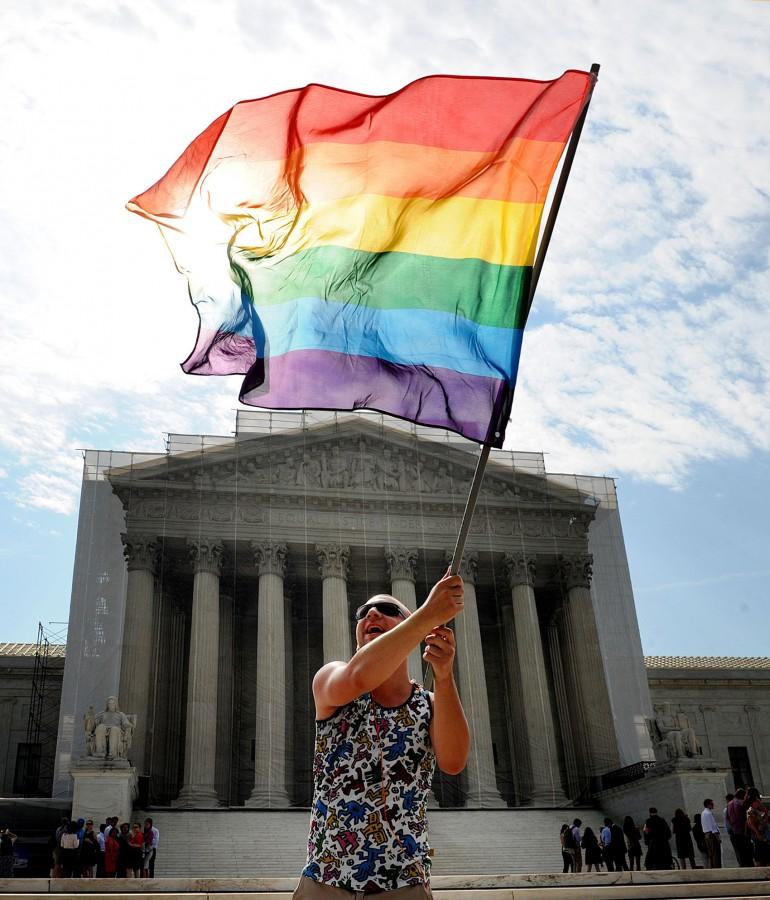 A demonstrator waves a flag in front of the U.S. Supreme Court on Monday, June 24, 2013, in Washington, DC. The court is expected to rule on a case on the Defense of Marriage Act and other gay rights issues this week. (Olivier Douliery/Abaca Press/MCT)