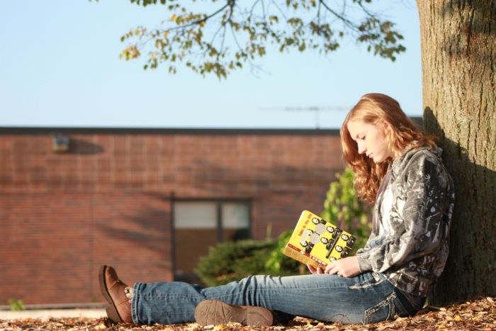 Flipping through pages in the morning sunlight,  sophomore Madison Stowe reads Hole in My Life.  Fans of the book eagerly await the book signing on Oct. 17 in Chelsea at the Washington Street Education Center.