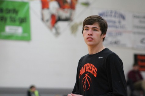 Senior Charlie Young, warms up to play against Lansing Christian. “I was shooting some baskets to get the pre-game jitters out,” Young said. They beat Lansing Christian 49-47.