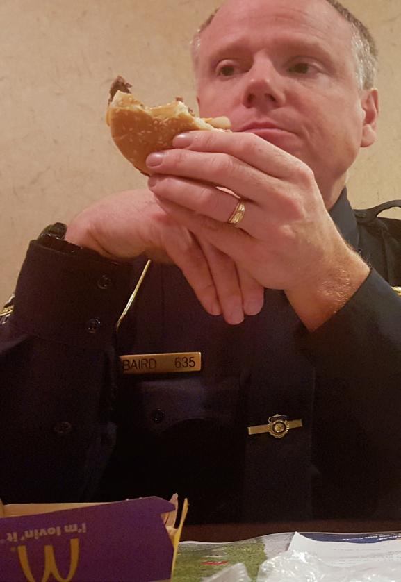 Officer James Baird enjoys his meal prepared by miniumum wage workers after a long day of work.
