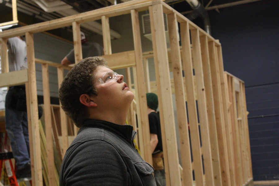 Jacob Hudson, a junior attending his second year of construction tech, searches for flaws in the framing of the shed being built.