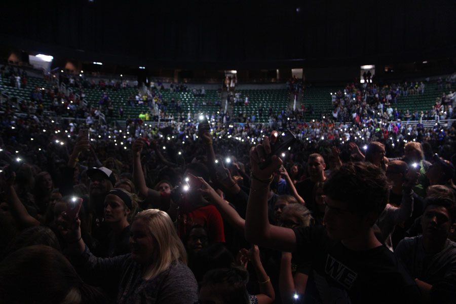  Singing along to Journey’s ‘Don’t Stop Believing,’ students wave their phone flashlights during the closing of the event. The song was picked through a poll on the Twitter page for Jostens Renaissance by the students attending.