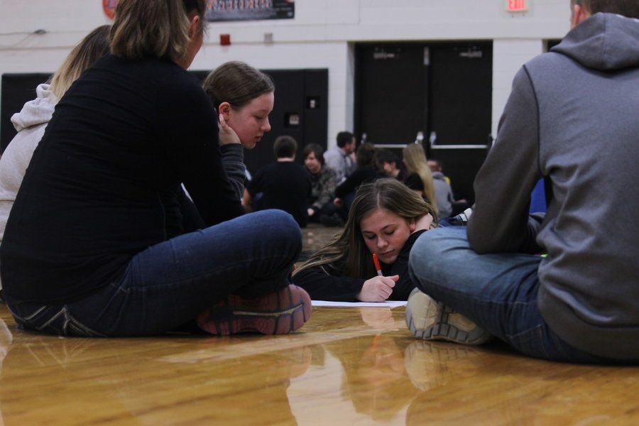 Along with the rest of her group, freshman Kelsey Andrews shares her ideas as to what she thinks helps strengthen high school students’ abilities to treat people with respect as freshman Alexis Killinger writes down a list in the gym on Friday, February 10. 
