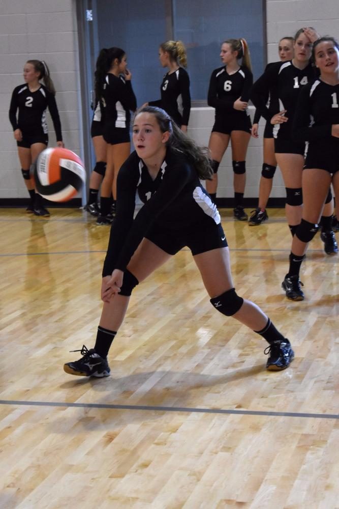 Determined, freshman Hailey Howard prepares to bump the volleyball during warm up before the first match against Olivet.