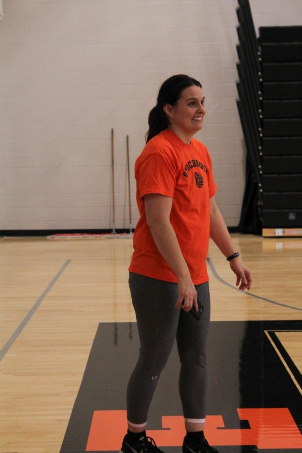 Showing her sophomore girls how to properly serve the ball, coach Villegas laughs as she watches the players learn from their unsuccessful attempts at serving the ball to their partners.

