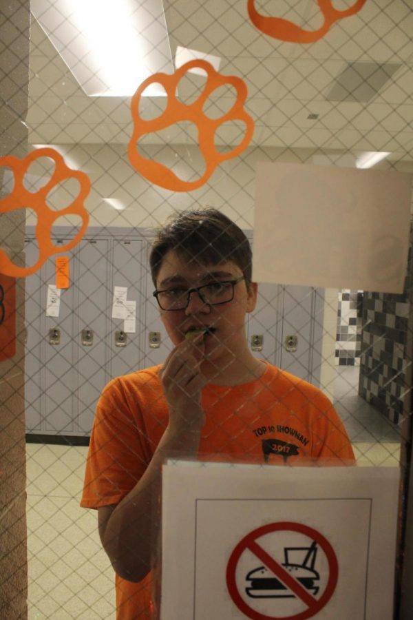 In a mocking mood, sophomore Evan Williams stands outside Spanish teacher Christina Villegas room eating a snack. Villegas, one of many instructors, allows no food in her classroom.