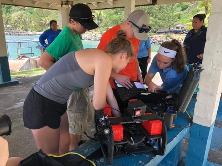 While on location in the South Pacific, junior Kael Bunce works on the computer to fix the broken Pixhawk, the ROVs autopilot, junior Kaleb Adkins and Sophomores Chelsey Asqith and Hailey Howard help Bunce resolve the issue.