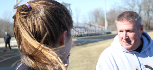 Track Coach Chuck Bumpus instructs freshman Brooklyn Roshow how to run with proper form and a steady pace on a windy spring day.Kids, in general, are jet lagged from school work that they have already dealt with earlier, Bumpus said.