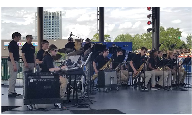 Performing the songs that they rehearsed numerous times on a busy day in Disney Springs, the concert band plays their instruments to melodies such as, Play that Funky Music and Boogie Shoes.