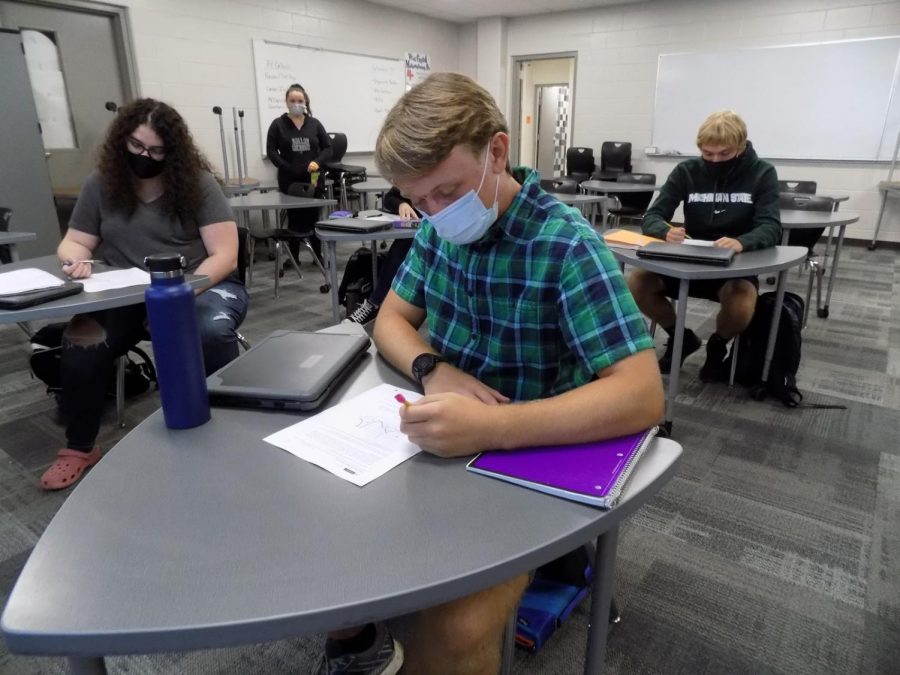 Seniors Diane Evans, Wyatt Whitaker, and Brock Jones do their work in school while socially distanced and following government protocols regarding COVID. Whitaker and his classmates follow school rules to stay properly distanced while wearing masks and keeping their hands clean often.