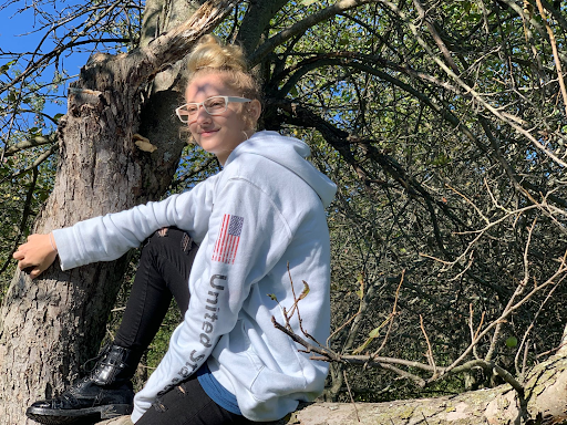 Kara Brown, a senior who has joined agriculture, poses in an apple tree. It is part of a cluster of trees on school property that agriculture cares for.