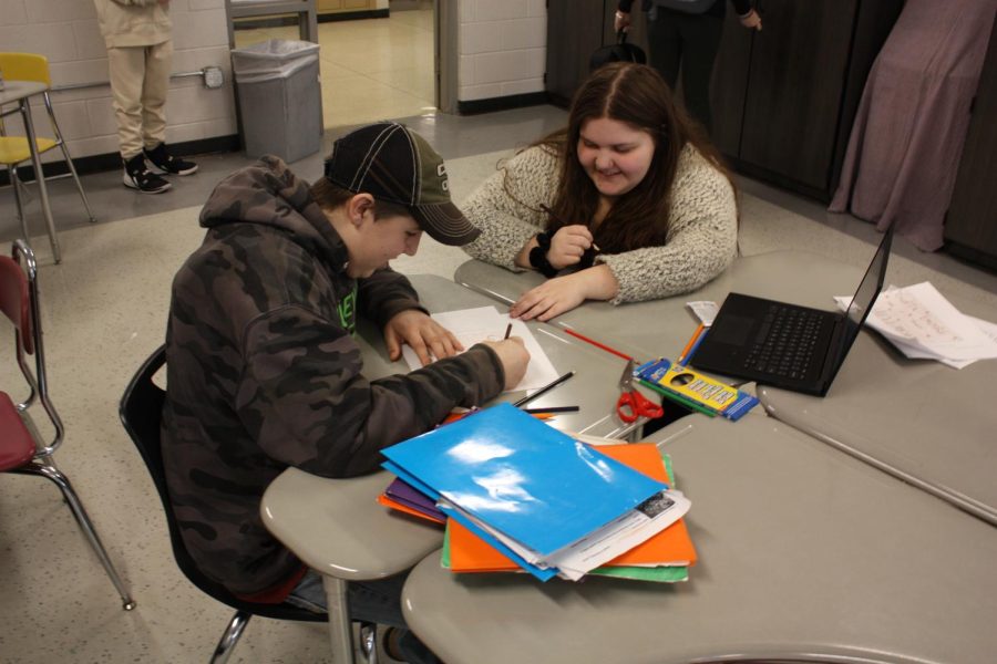 Senior Madi Gipe works with her link Travis Whitney, grade 8, to complete assignment.