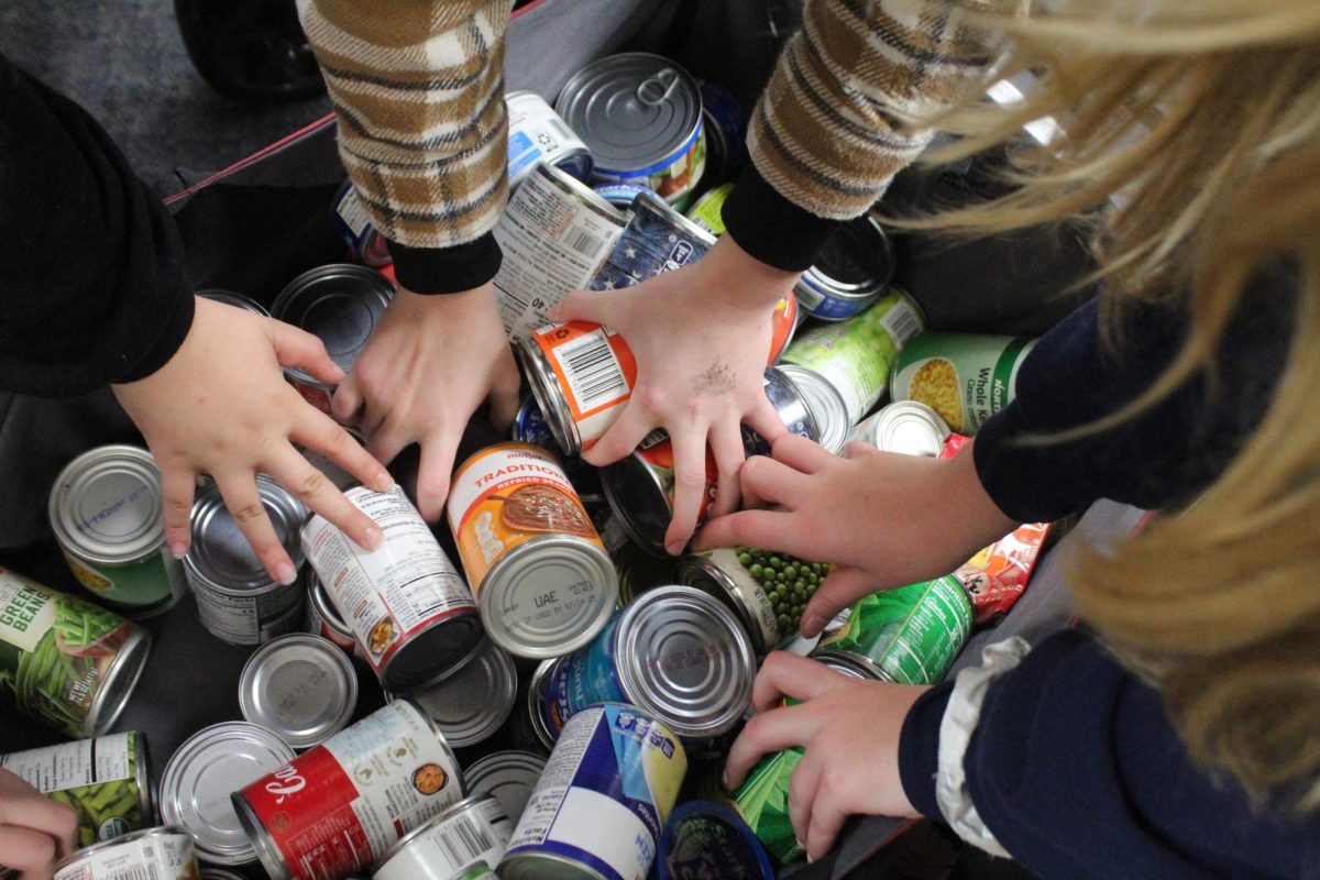 Heritage student council members work together to sort through the canned food donations at Stockbridge Outreach.