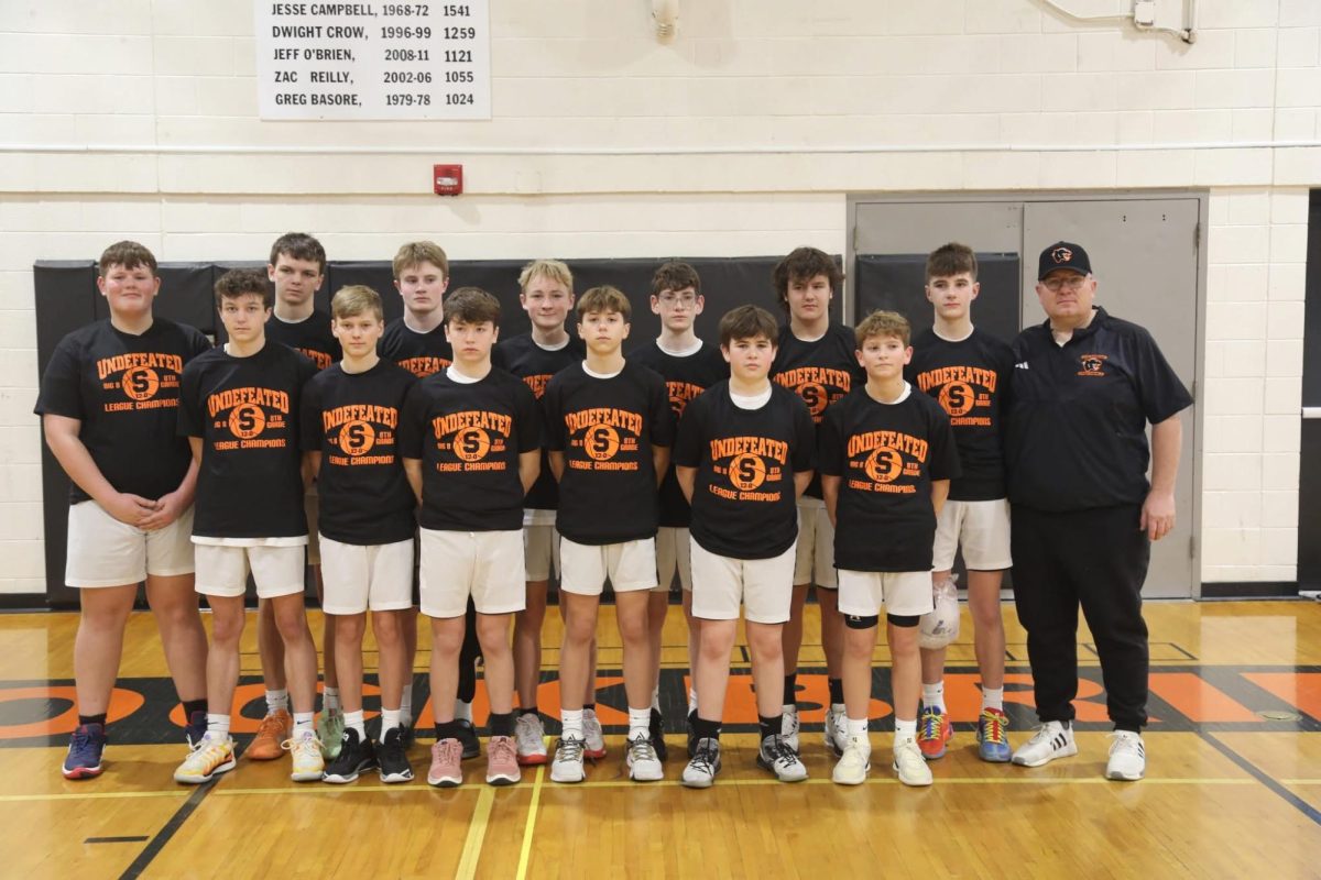 The eighth grade boys basketball team stands confident.